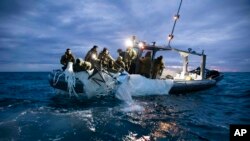 На фотографии, предоставленной ВМС США, изображены моряки, поднимающие высотный аэростат наблюдения у побережья Миртл-Бич, Южная Каролина, 5 февраля 2023 года