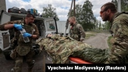 Военные медики оказывают помощь раненому украинскому военнослужащему недалеко от города Волчанск в Харьковской области, 12 мая 2024 года