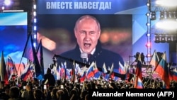 Президент России Владимир Путин (на экране на Красной площади) выступает на митинге и концерте в честь аннексии четырех областей Украины, оккупированных российскими войсками. Москва, 30 сентября 2022 года