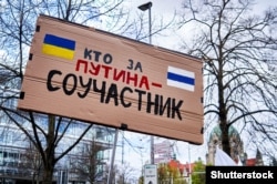 Плакат «Кто за Путина – соучастник» на демонстрации против войны России в Украине, Ганновер, Германия, 9 апреля 2022 года